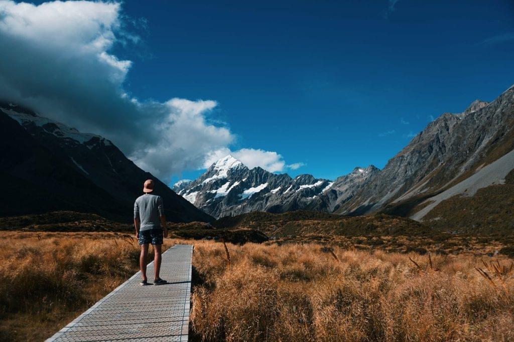 5 aspects of regenerative tourism - person looking at snow covered mountain